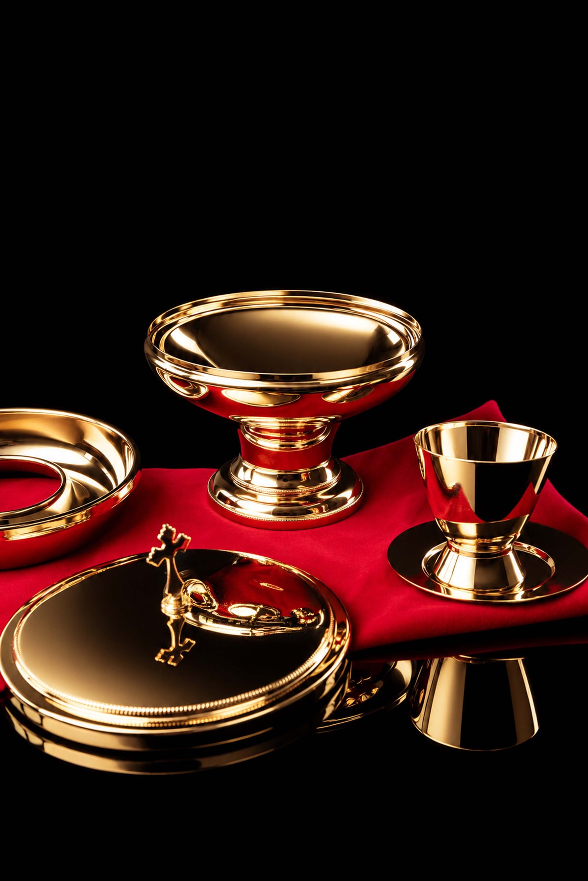 Puszka liturgiczna pod dwoma postaciami z pokrywą i krzyżem, pokazana wśród naczyń liturgicznych