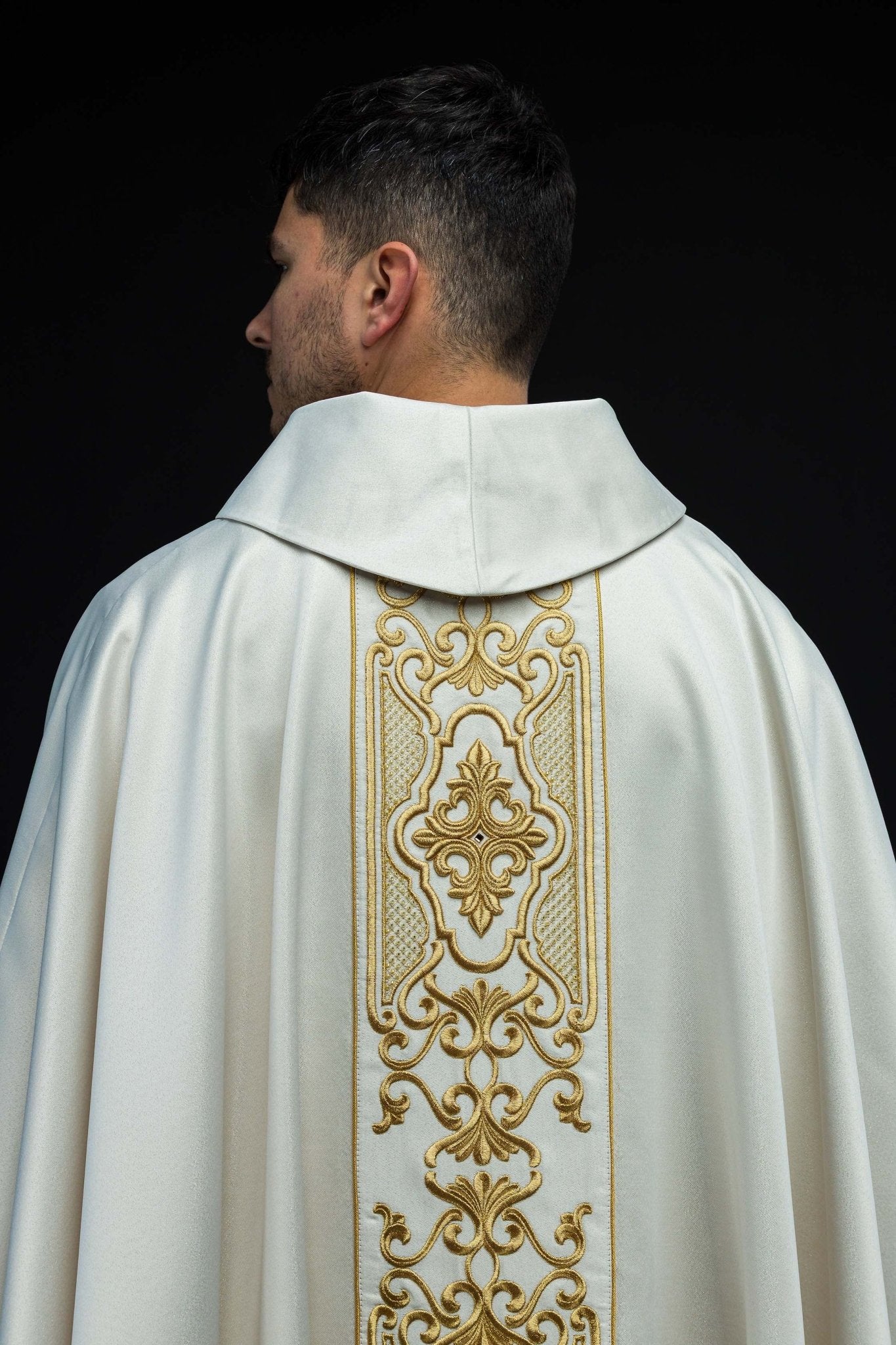 Ornat z połyskującej tkaniny z bogatym złotym haftem na pasie
