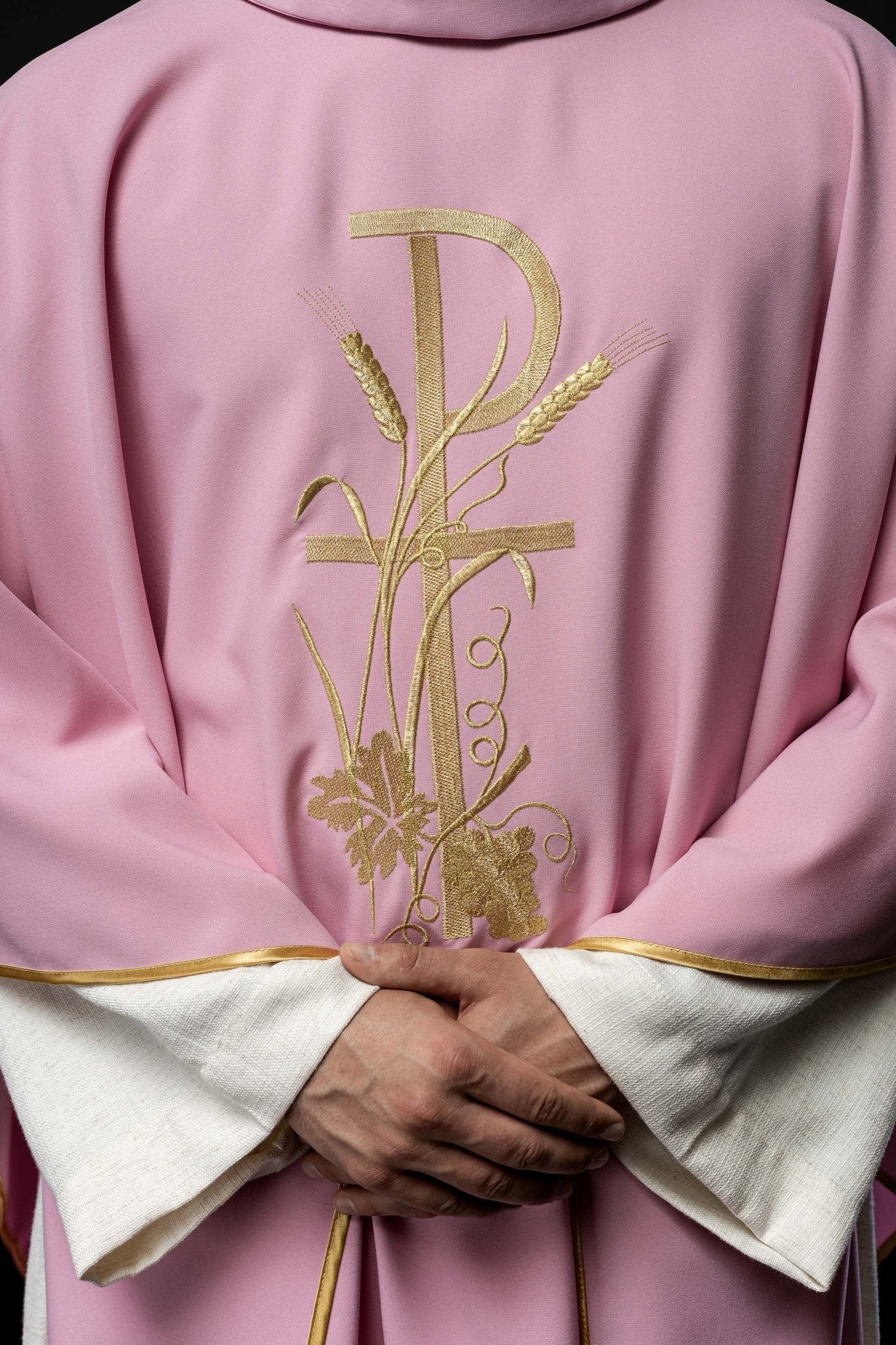 Różowy ornat z złotym haftem krzyża